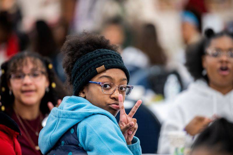 Girls of Color Summit previous event with a girl doing a peace sign